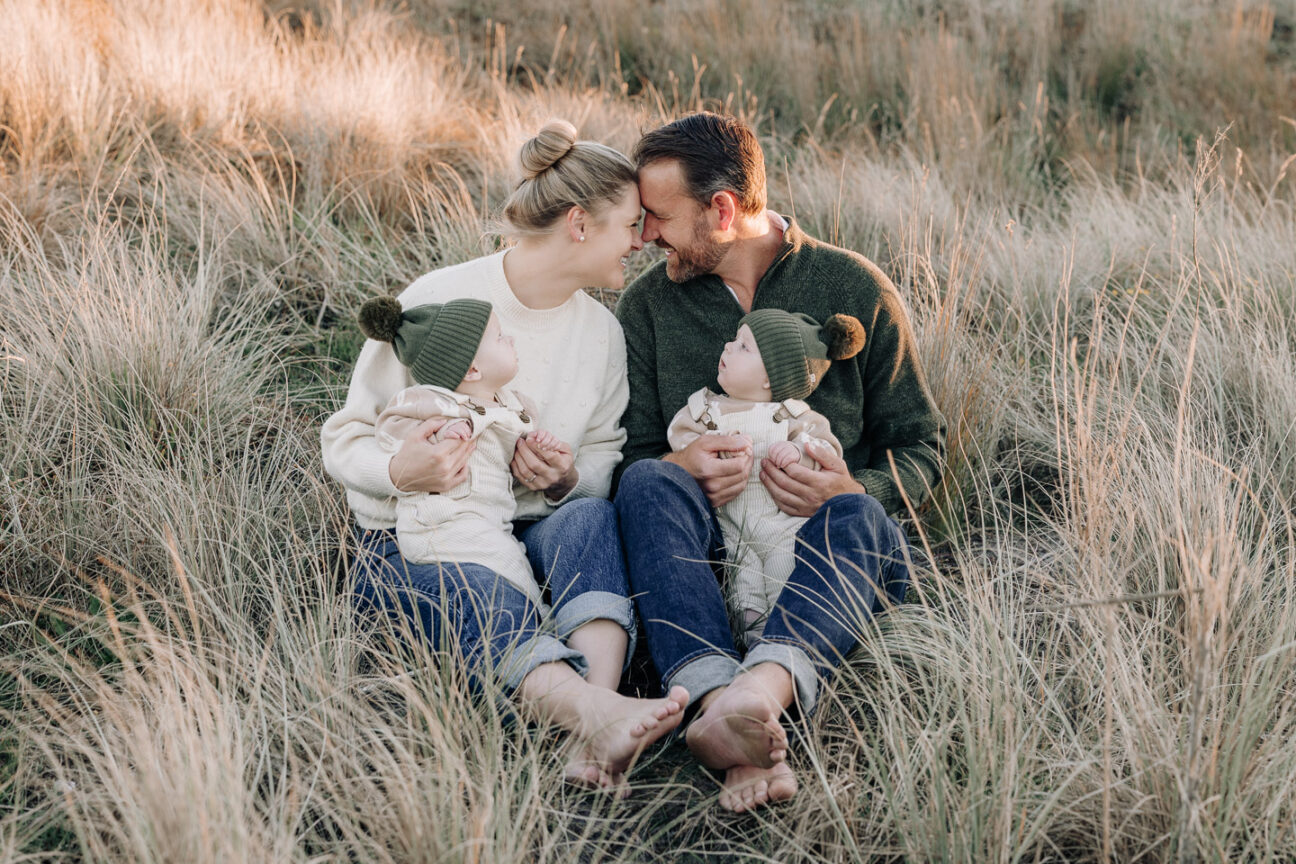 family photo with twin babies looking at mum and dad