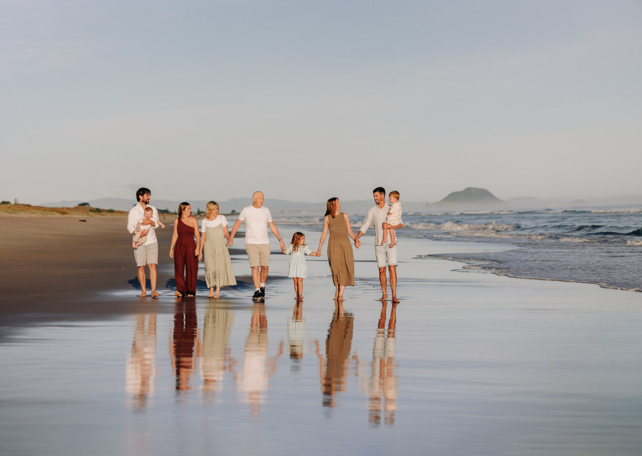 family walking papamoa beach reflection in sand