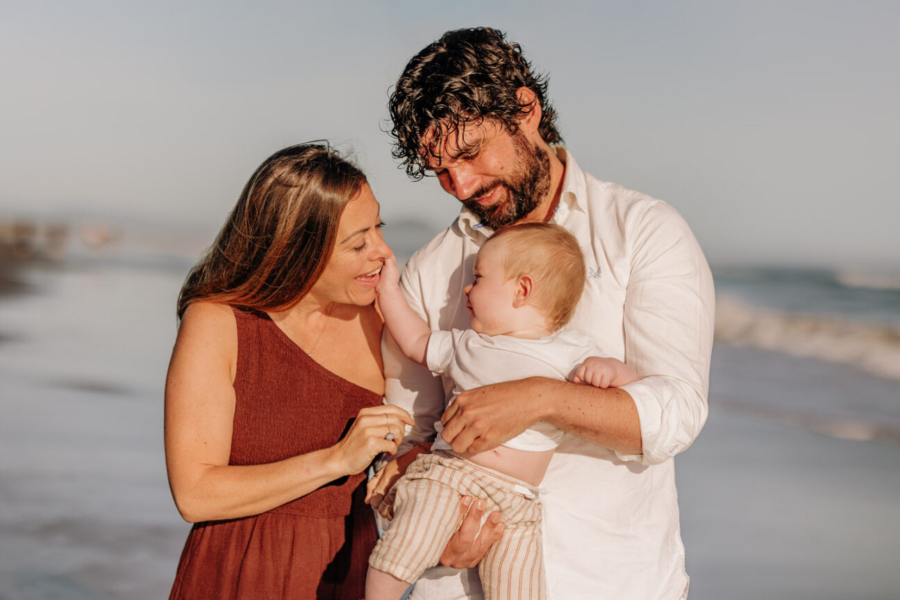 baby fun moment with mum and dad on the beach
